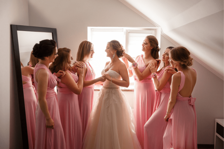 Bride and bridesmaids in pink dresses preparing for a wedding day event.