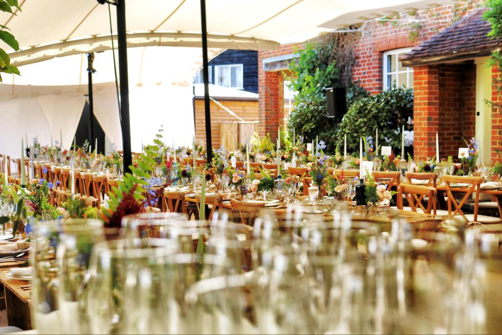 Elegant wedding reception setup with vineyard chairs and floral centerpieces for event budgeting.