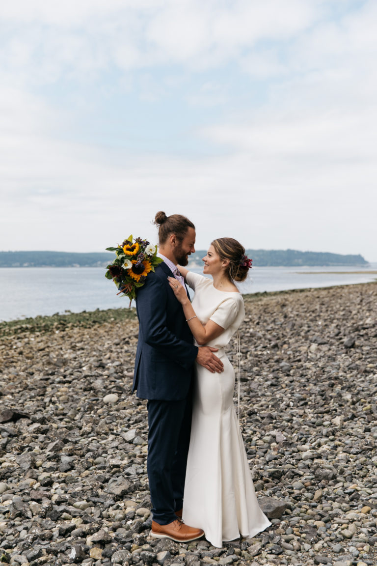 Bride and groom embracing with sunflowers, a personalized wedding day celebration near Poulsbo, WA