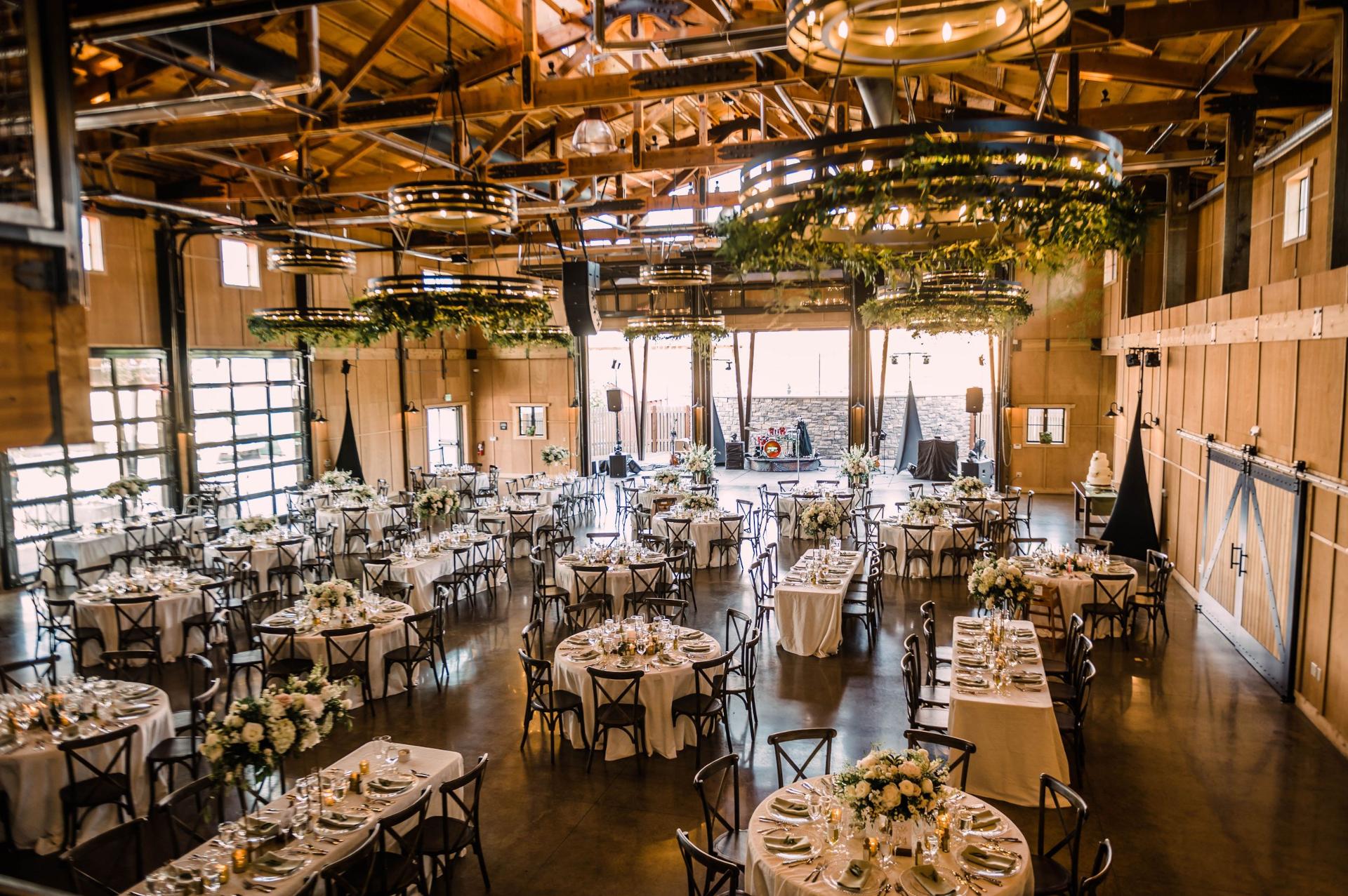 Puyallup wedding reception in event hall with floral chandeliers and table settings Farm 12