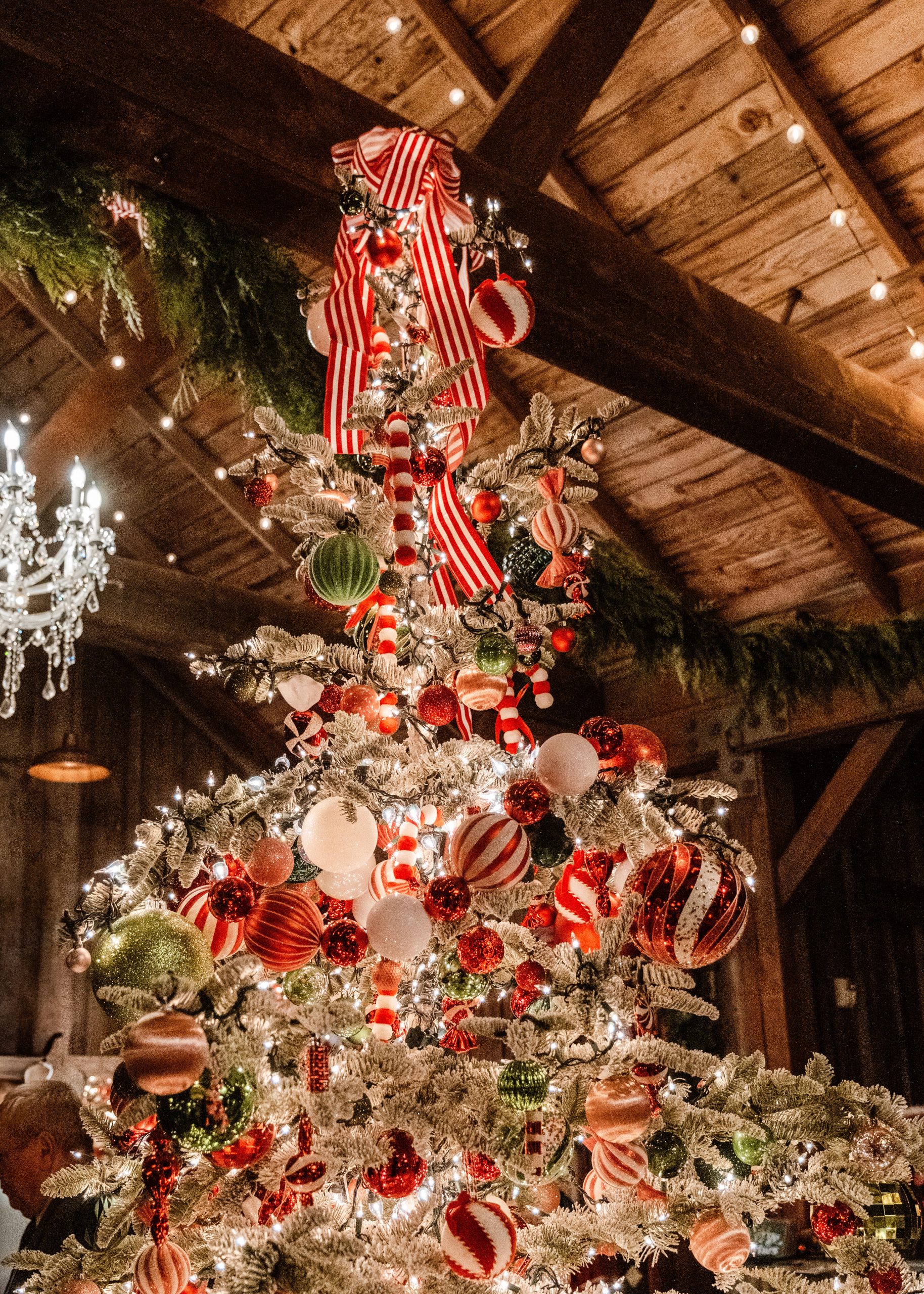 Vintage Christmas tree décor with red and green ornaments and ribbon, evoking 1940s and 50s glamour.
